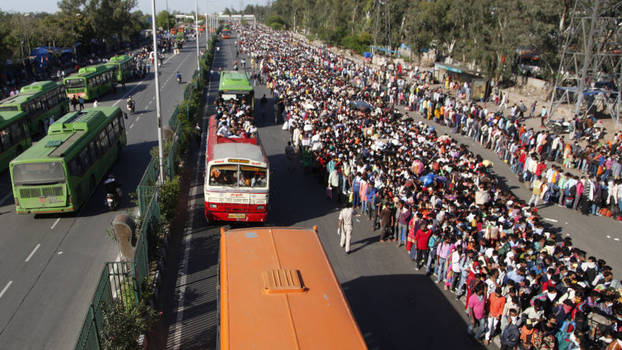 Wanderarbeiter*innen warten in Neu-Delhi auf Busse